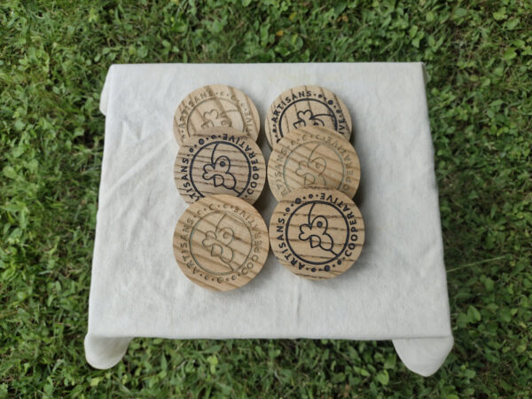 6 Artisans Co-op coasters on a small table