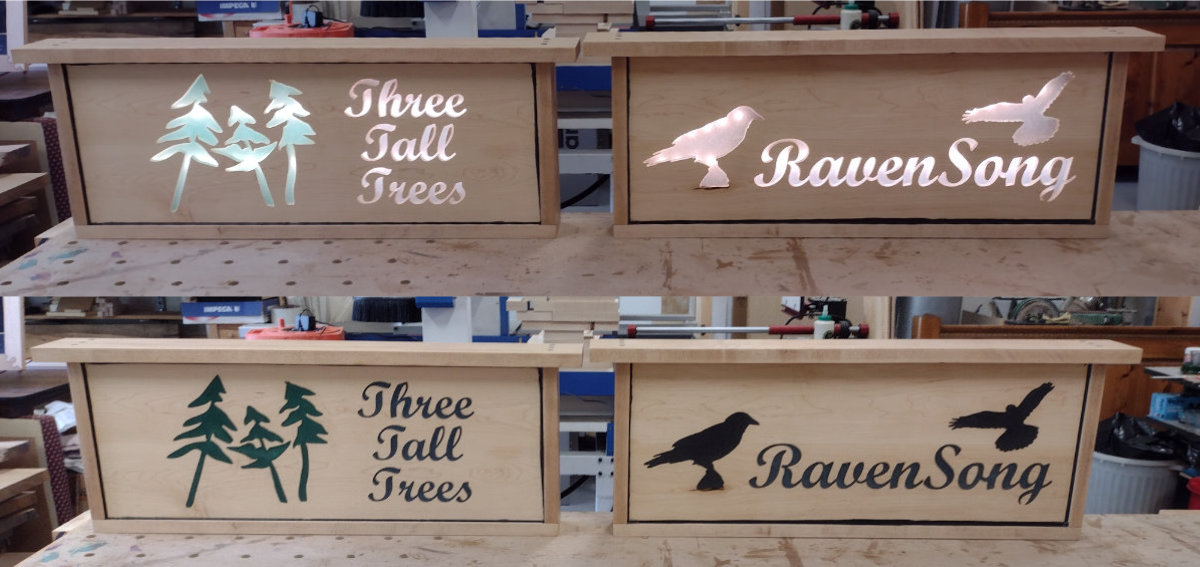 Two backlit signs. Left one says "Three Tall Trees" right one says "RavenSong".